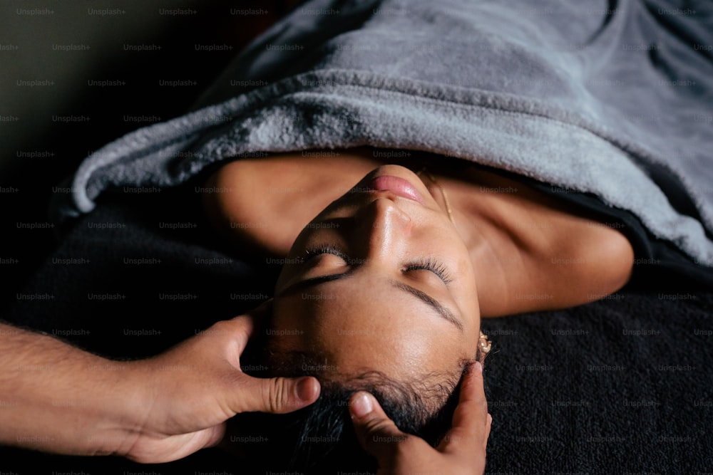 a man laying on top of a bed under a blanket