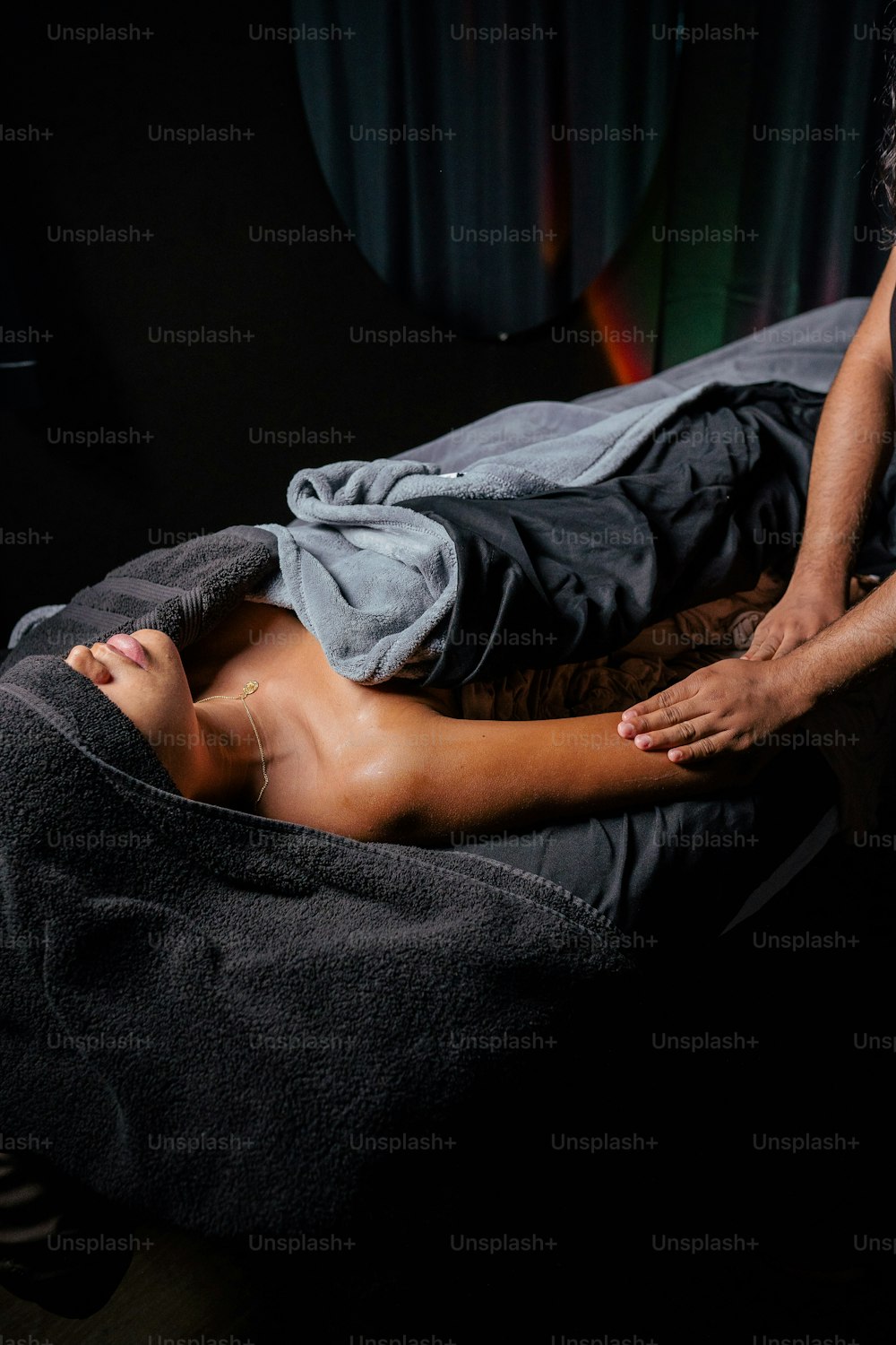 um homem deitado em cima de uma cama coberto por um cobertor