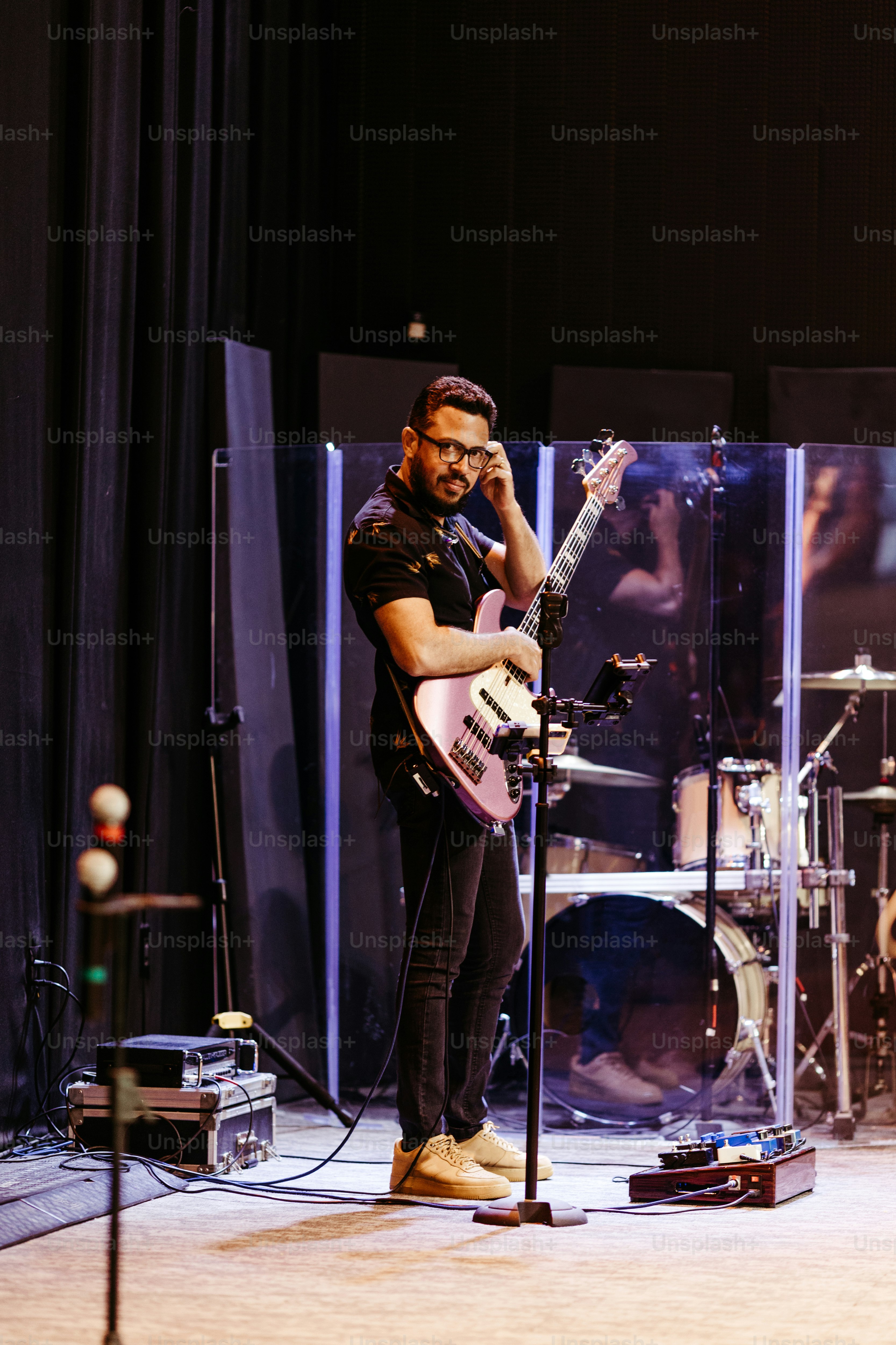 a man standing on a stage with a guitar