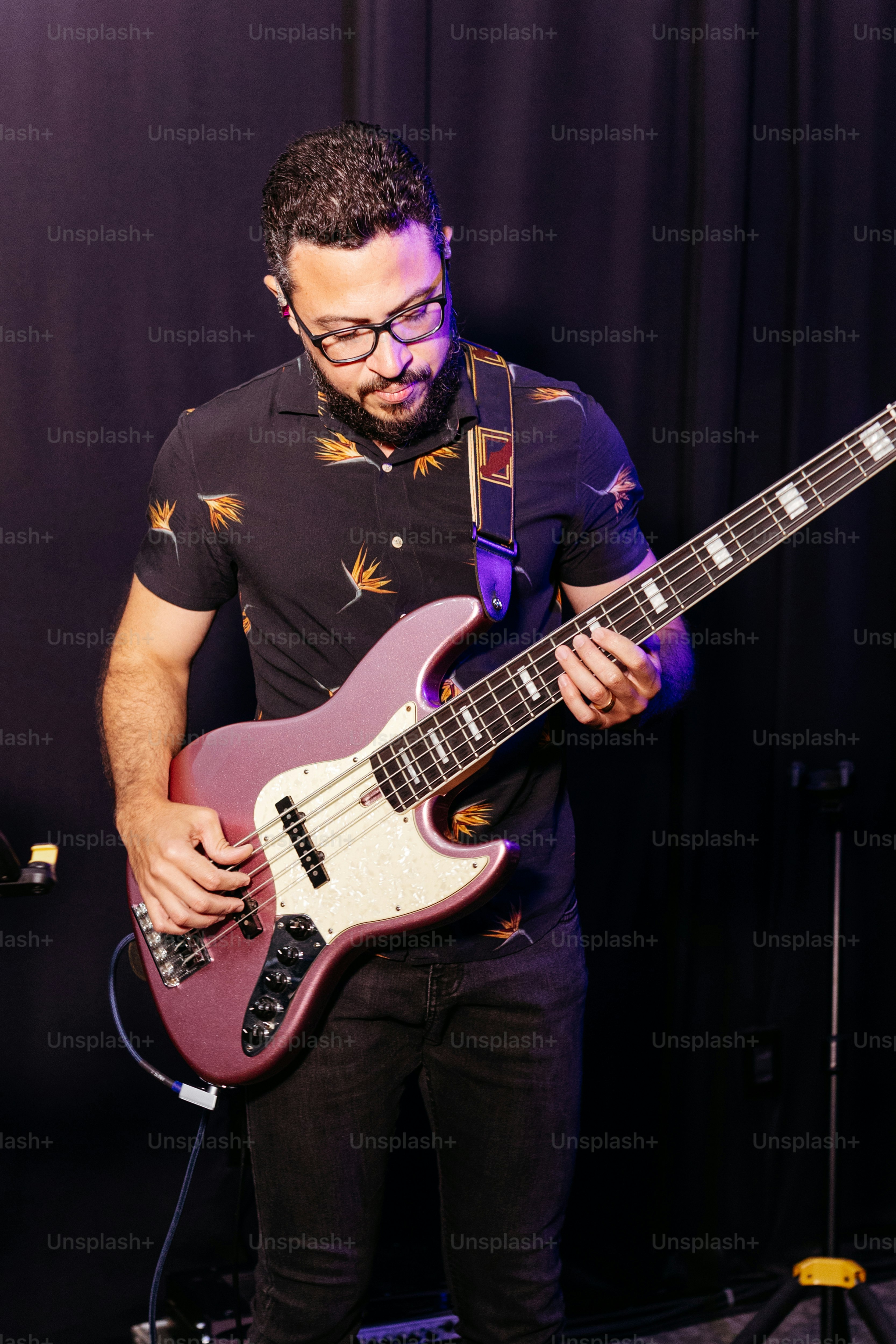 a man playing a guitar in front of a microphone