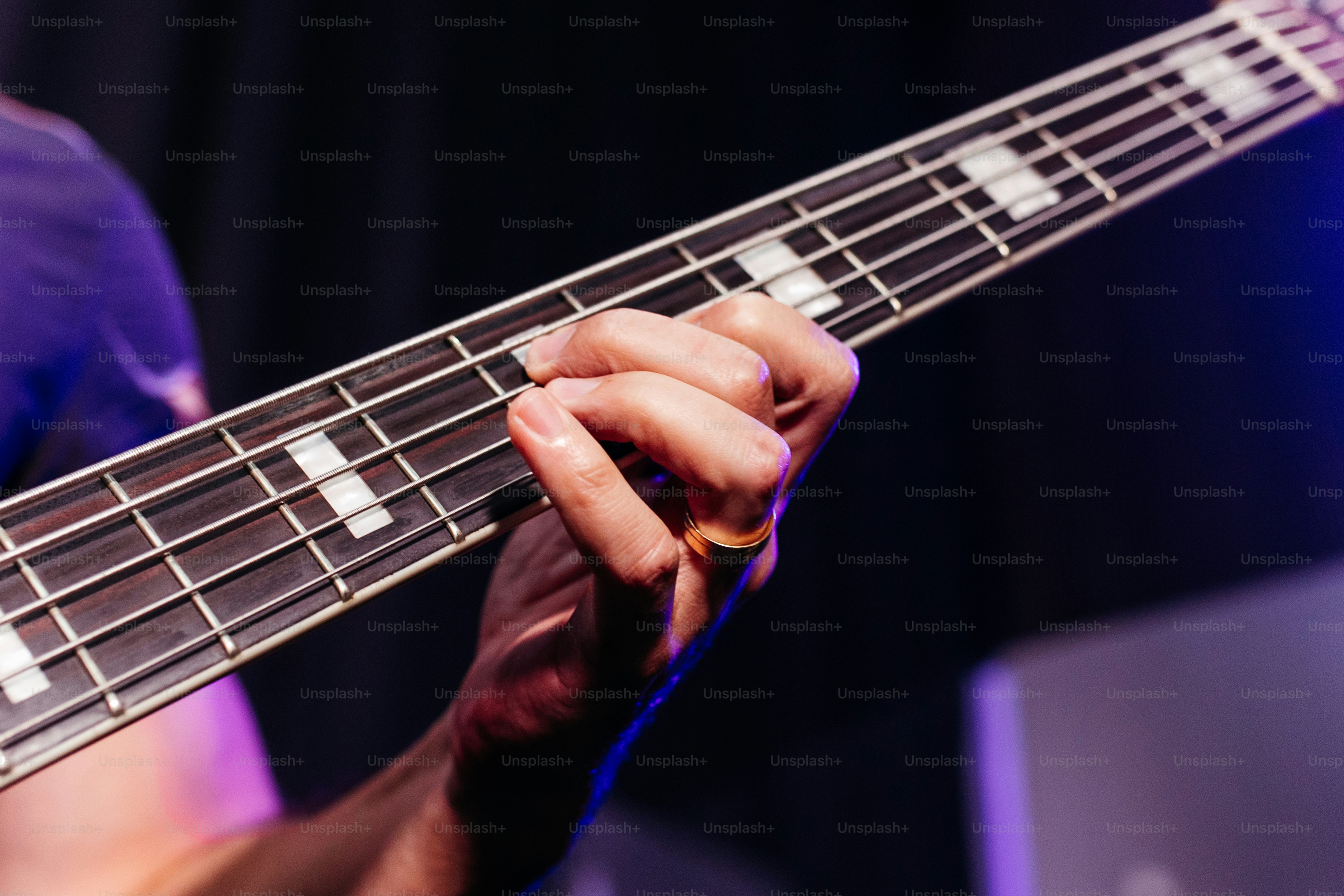 um close up de uma pessoa tocando um baixo