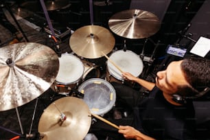 a man sitting in front of a drum set