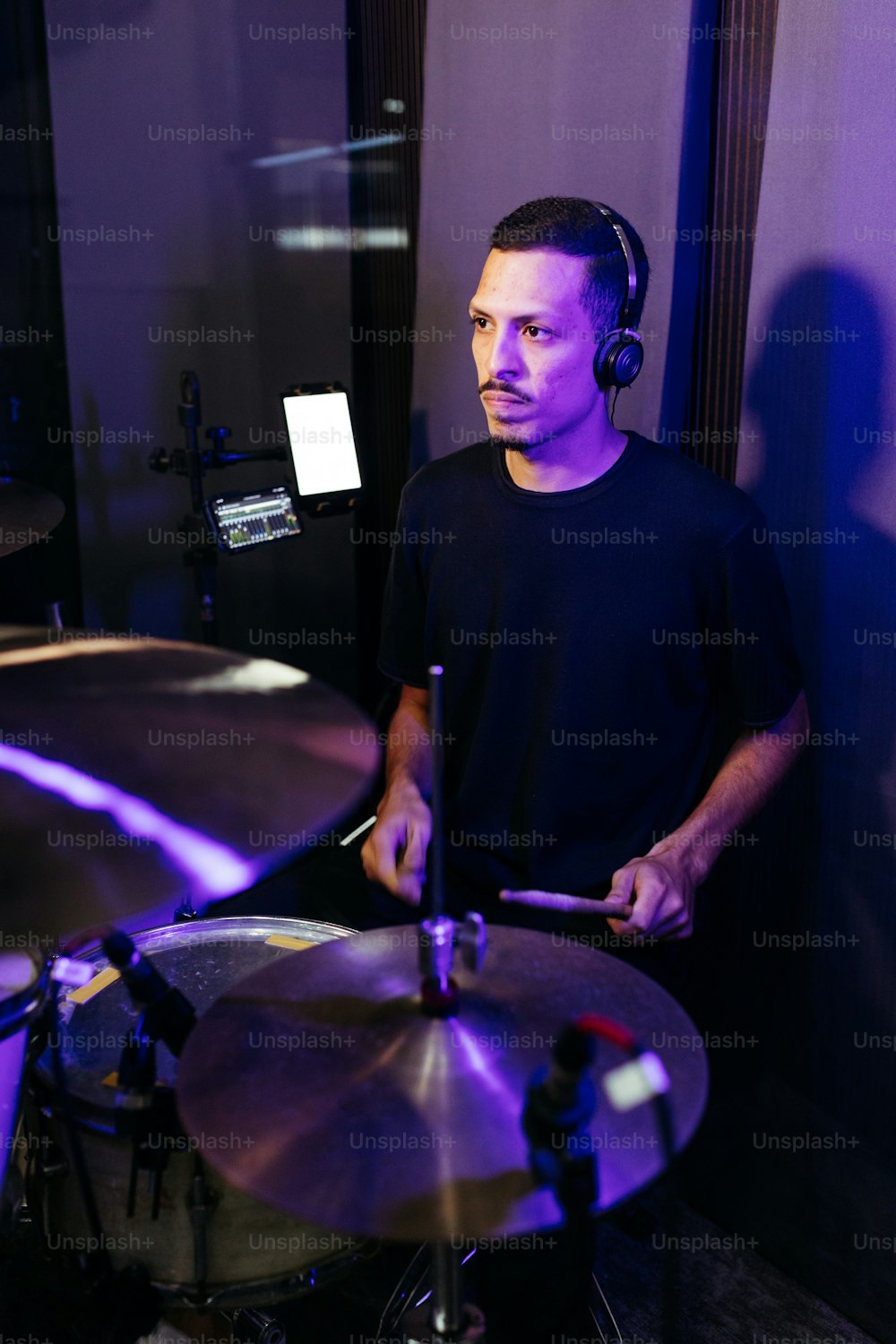 a man with headphones on playing a drum set
