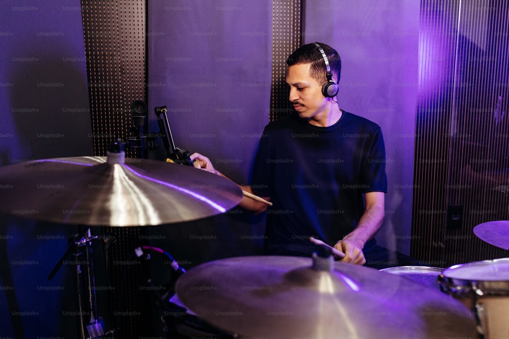 Un homme jouant de la batterie dans un studio d’enregistrement