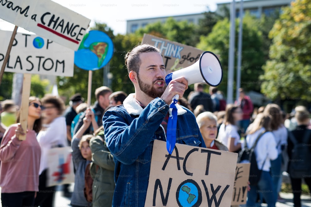 Ein Mann mit Plakaten und Verstärker im globalen Streik für den Klimawandel, schreit.