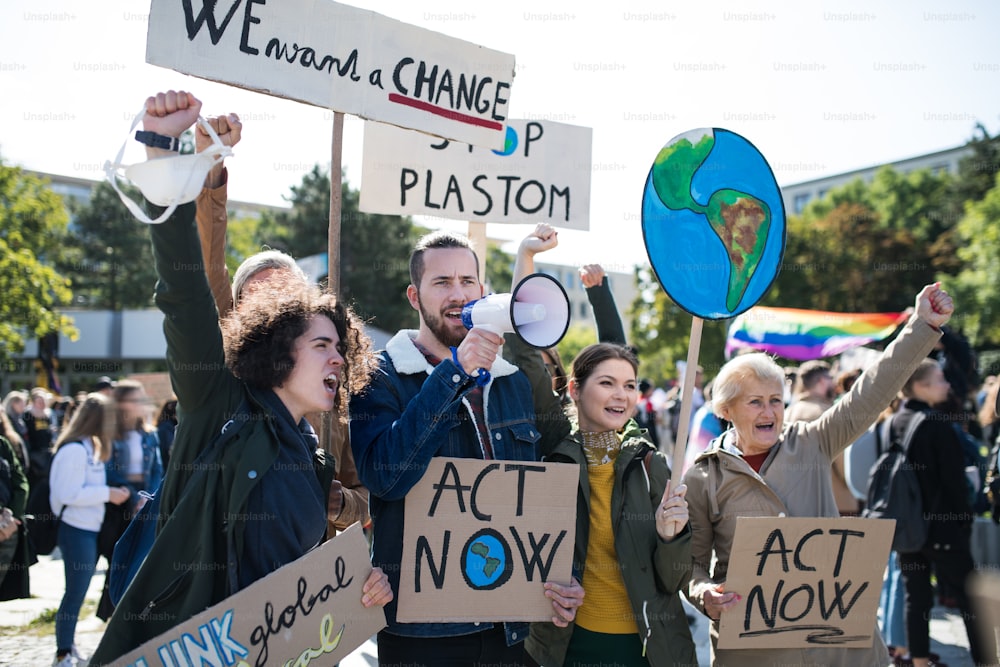 Personas con pancartas y amplificadores en una huelga global por el cambio climático, gritando.