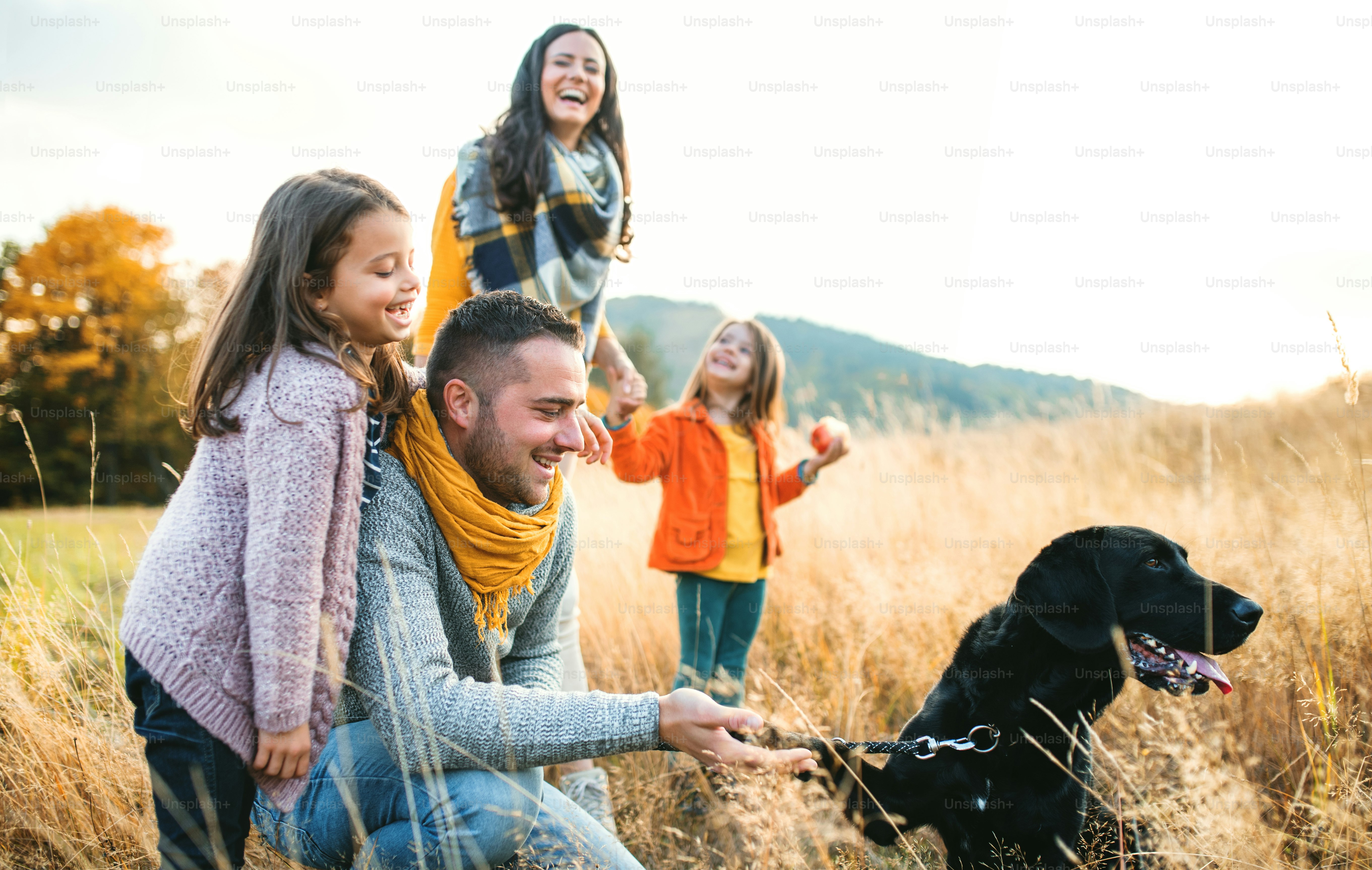 Foto Una familia joven con dos niños pequeños y un perro negro en un ...