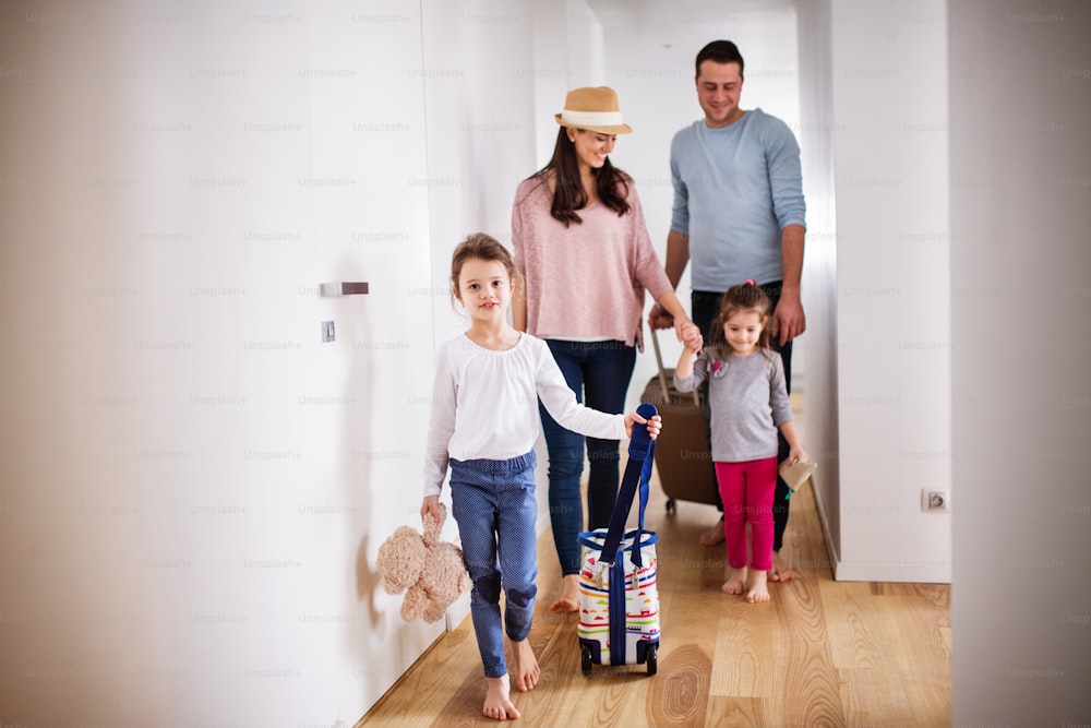 Young family with two children going on a holiday, walking through the corridor.