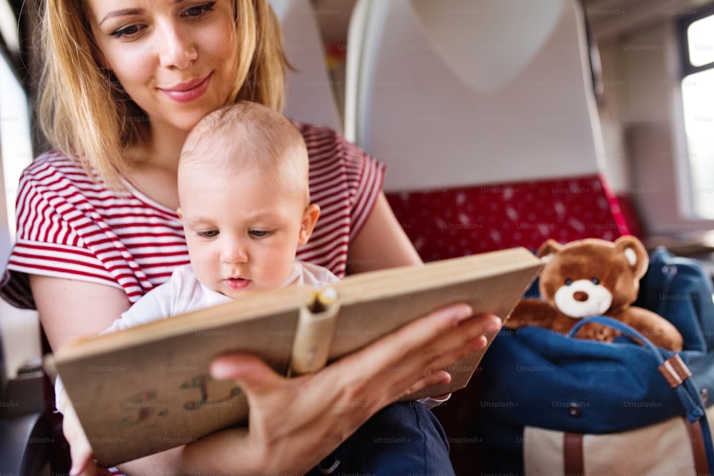 男の子と一緒に電車で旅行する若い母親。美しい女性と彼女の息子の鉄道の旅。