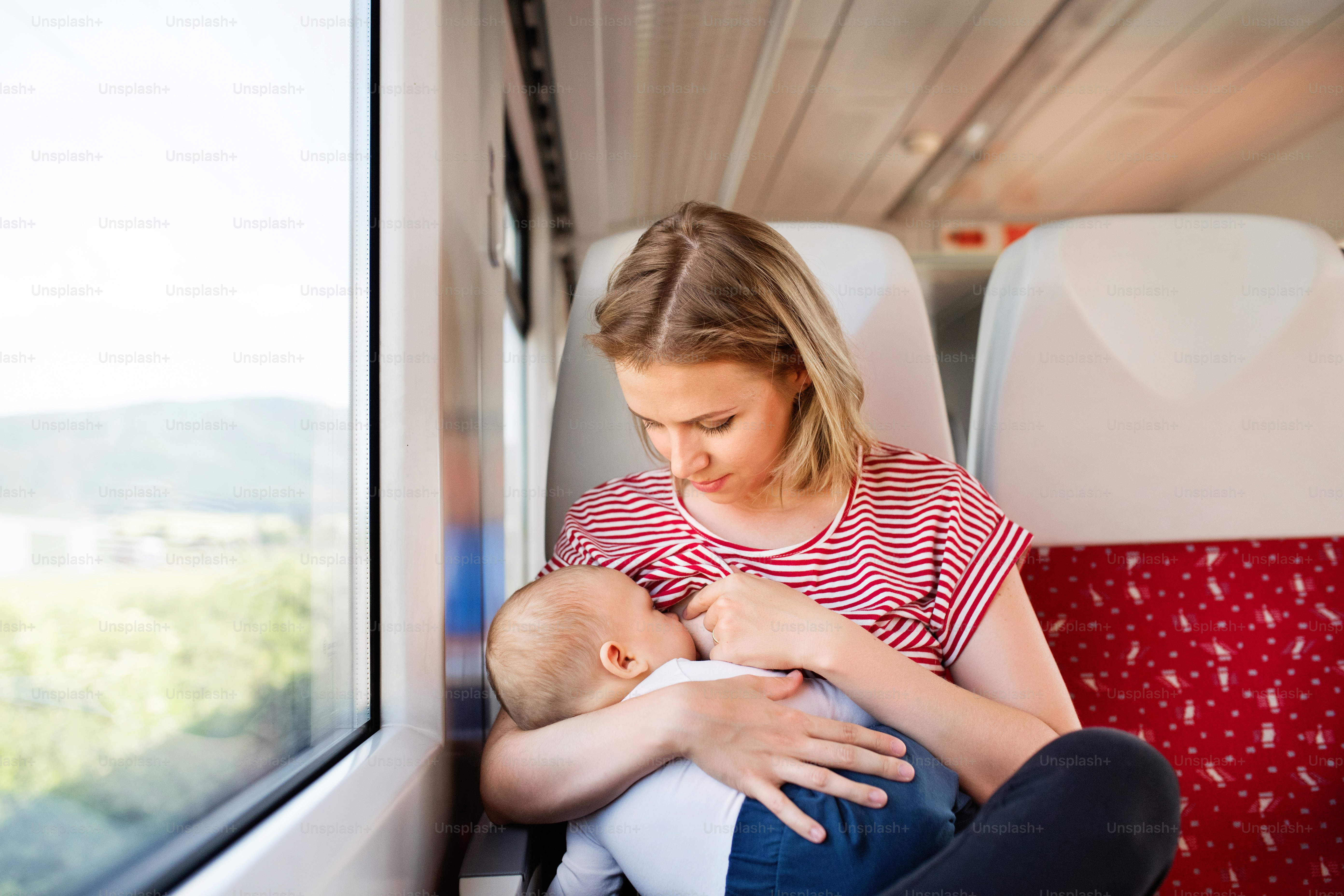 Junge Mutter, die mit dem kleinen Jungen mit dem Zug reist. Eisenbahnreise einer schönen Frau und ihres Sohnes