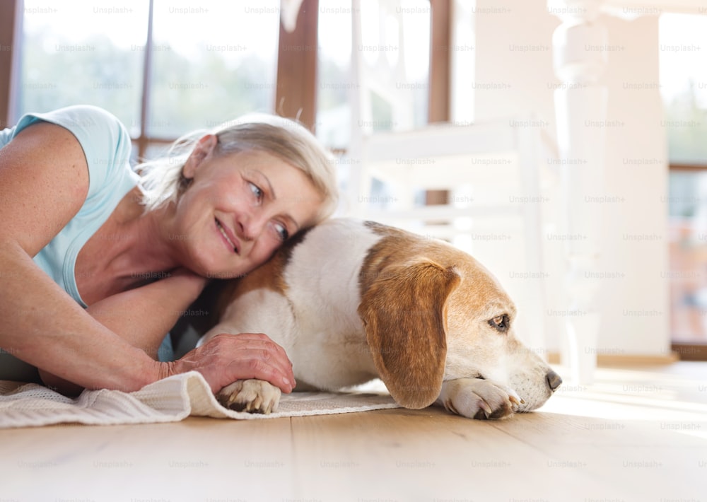 Senior woman with dog inside of her house.