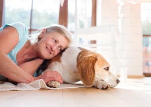 Senior woman with dog inside of her house.