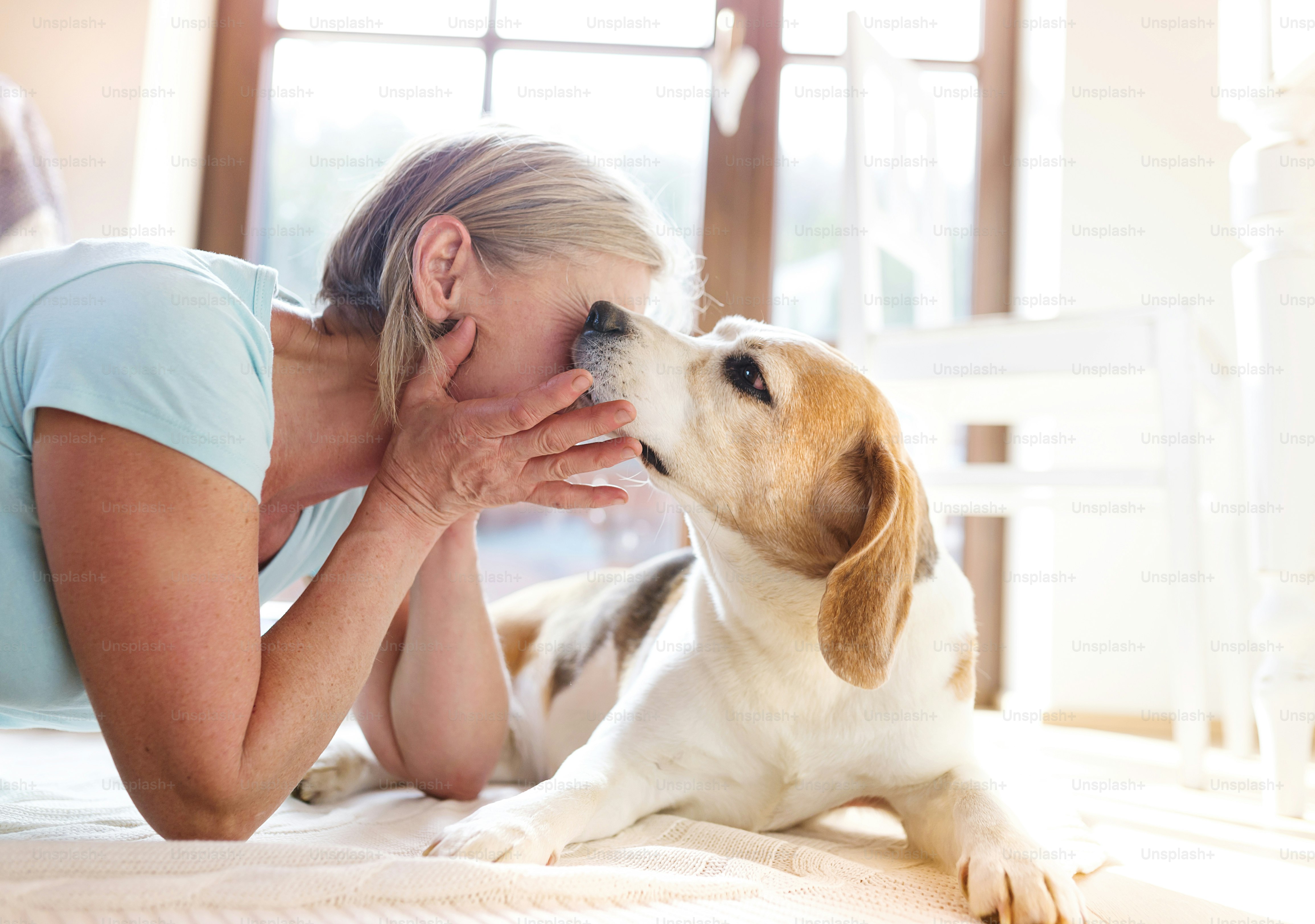Senior woman with dog inside of her house.