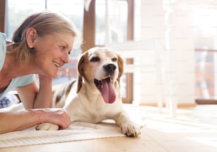 Senior woman with her dog inside of her house.