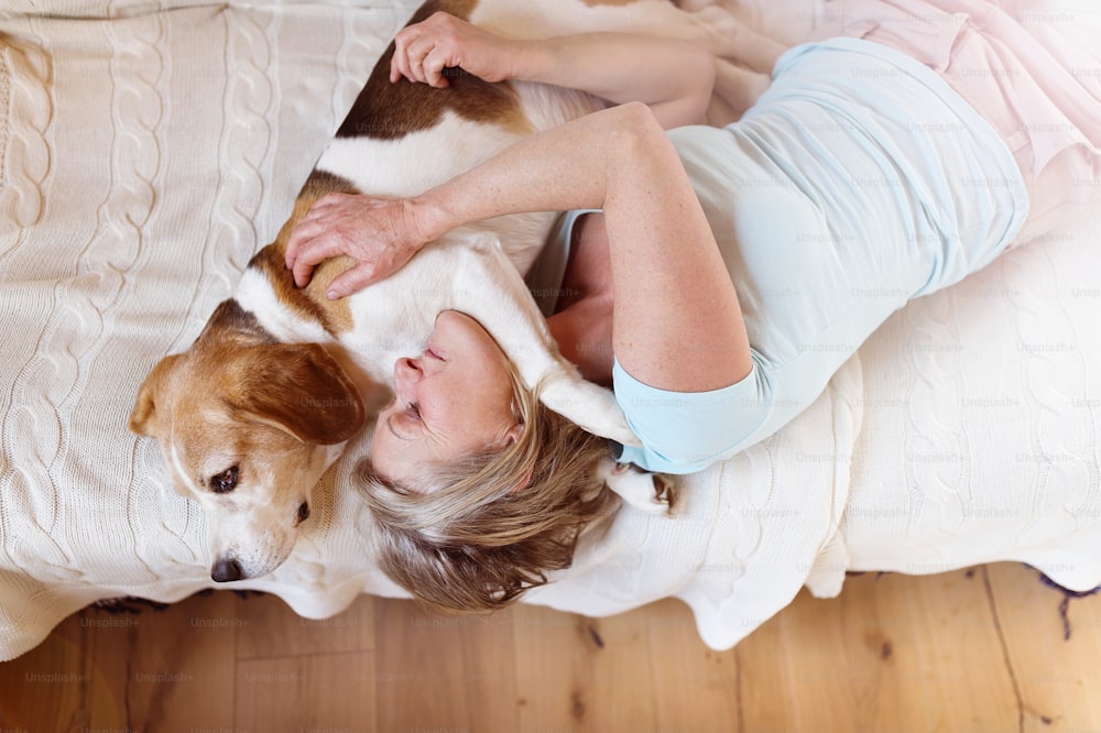 Senior woman with her dog inside of her house.