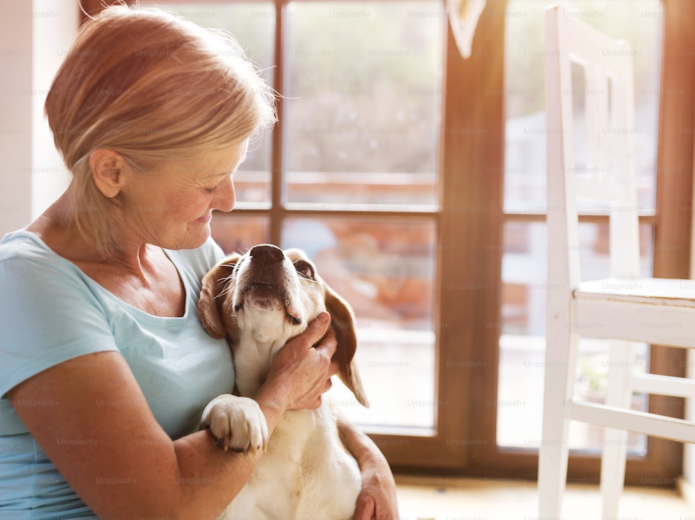 Senior woman with her dog inside of her house.