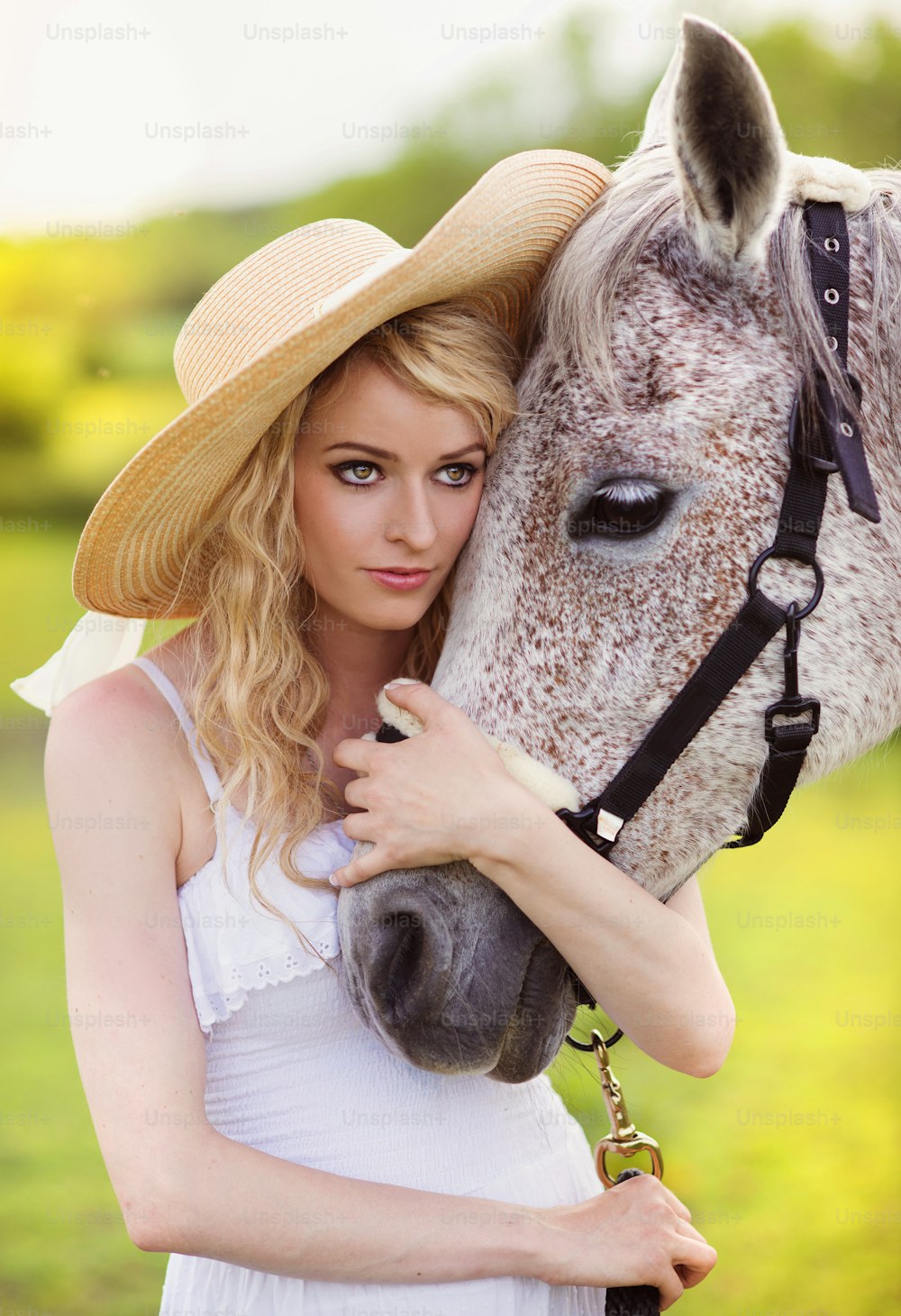 Woman in white dress walking with horse in green countryside