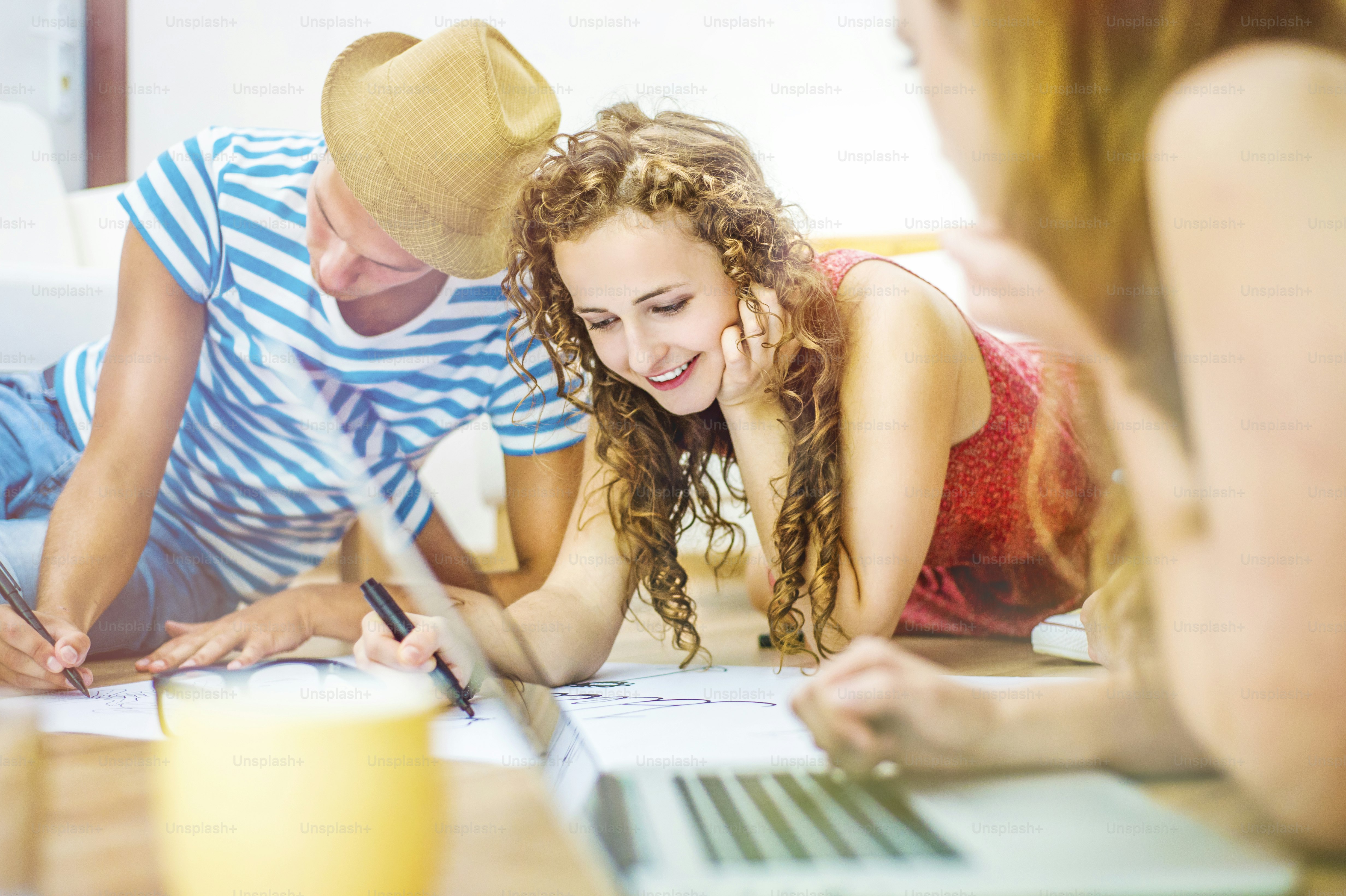 Group of young students studying together and preparing for exams in home interior