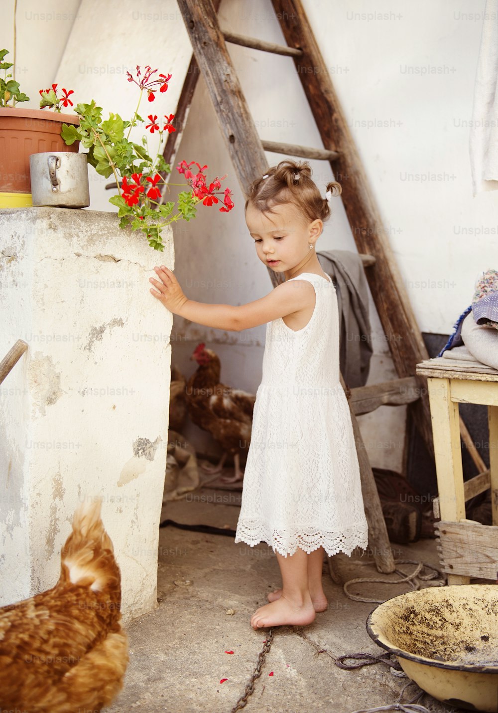 Happy little girl having fun in garden near the old farmhouse