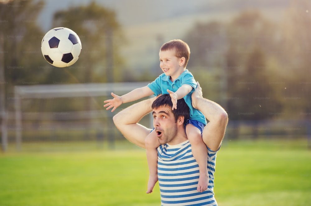 어린 아들과 함께 축구 경기장에서 즐거운 시간을 보내는 젊은 아버지