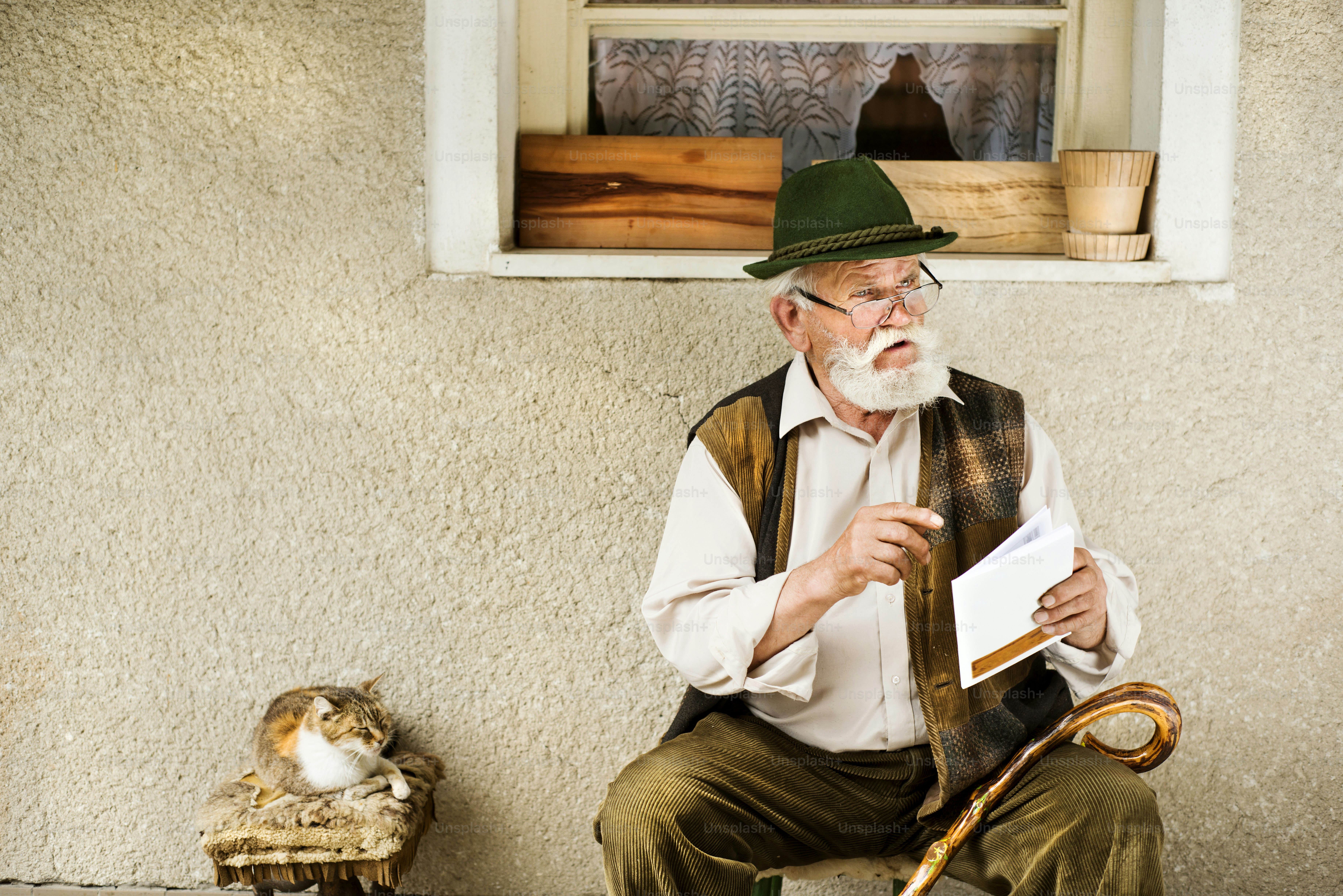 Old man reading the newspaper in front of his house