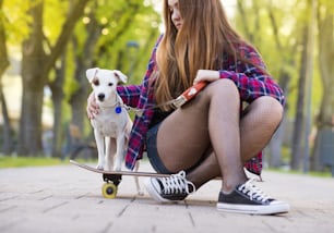 강아지와 함께 스케이트보드를 타는 십대 소녀