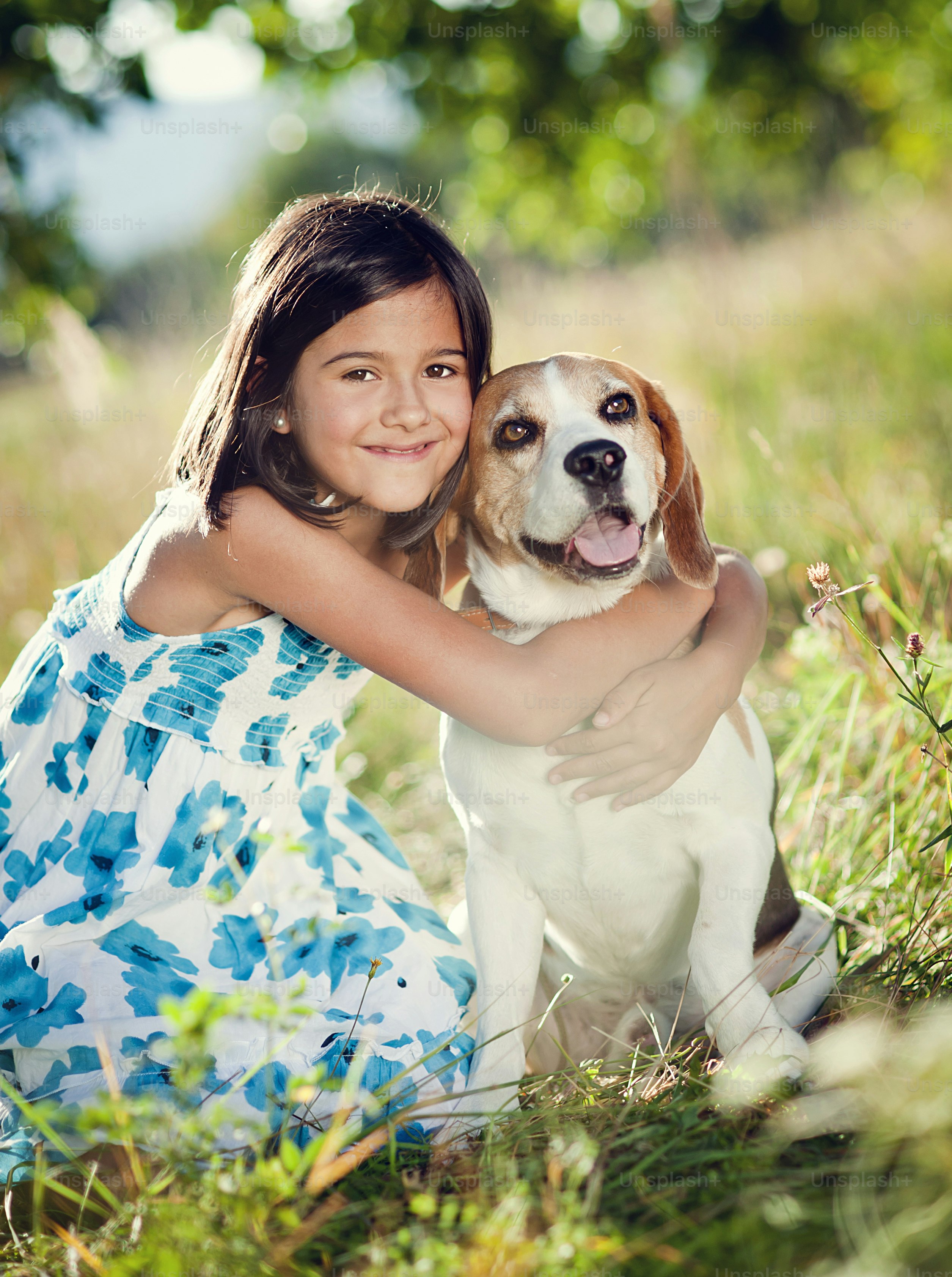 Cute little girl is playing with her dog in the green park