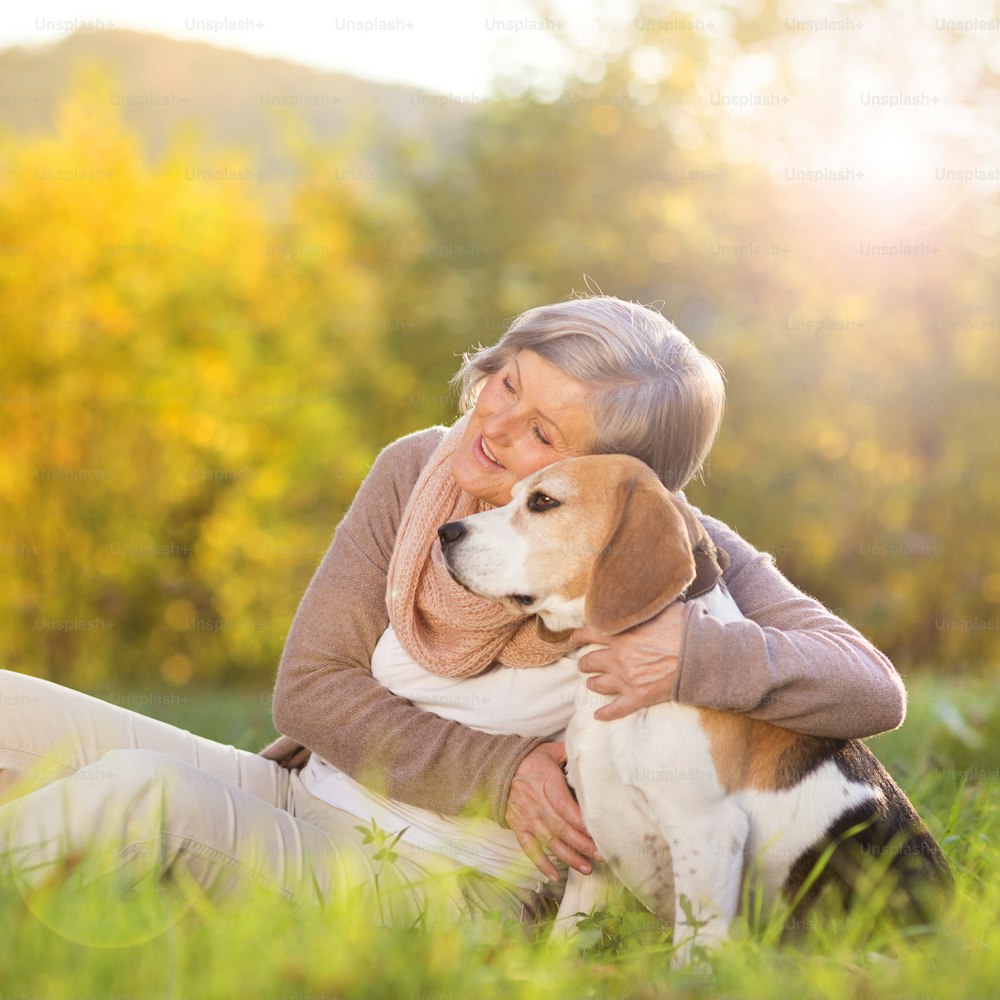 Donna anziana abbraccia il suo cane beagle in campagna