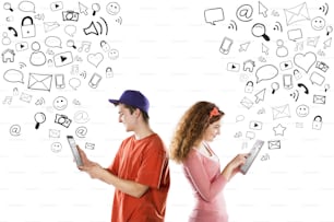 Lindo casal jovem com tablets está usando as mídias sociais