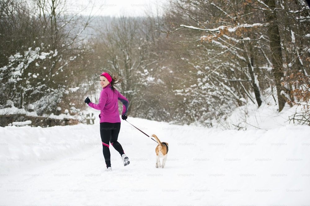 Athletin läuft während des Wintertrainings draußen bei kaltem Schneewetter.