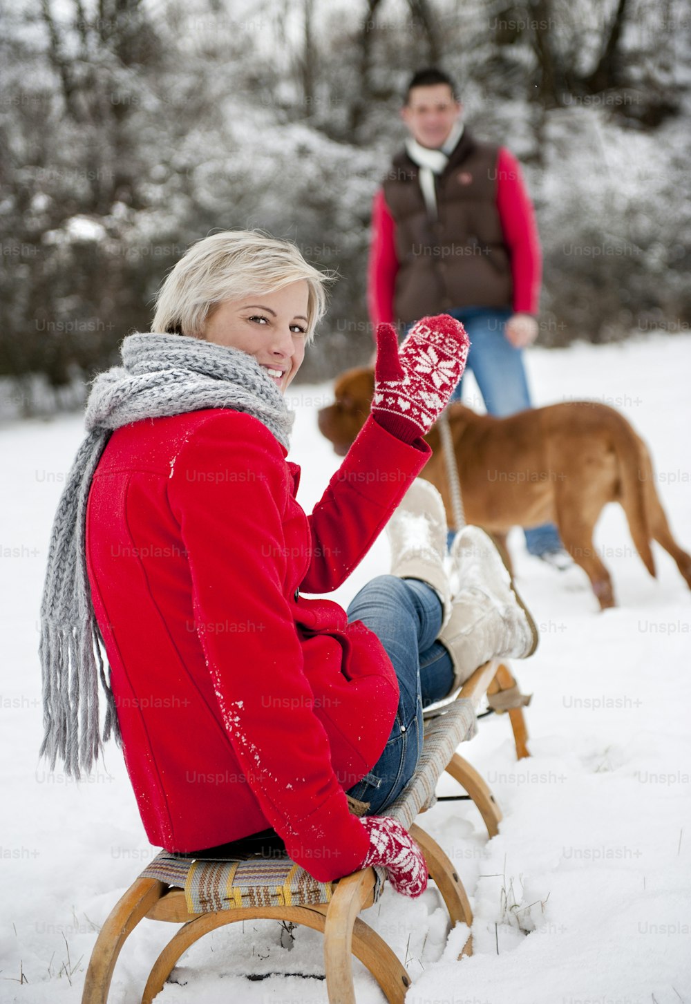 Woman and man are having walk with dog in winter snowy countryside