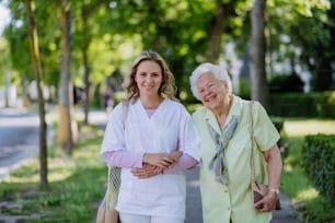Ritratto di badante con donna anziana sulla passeggiata nel parco.