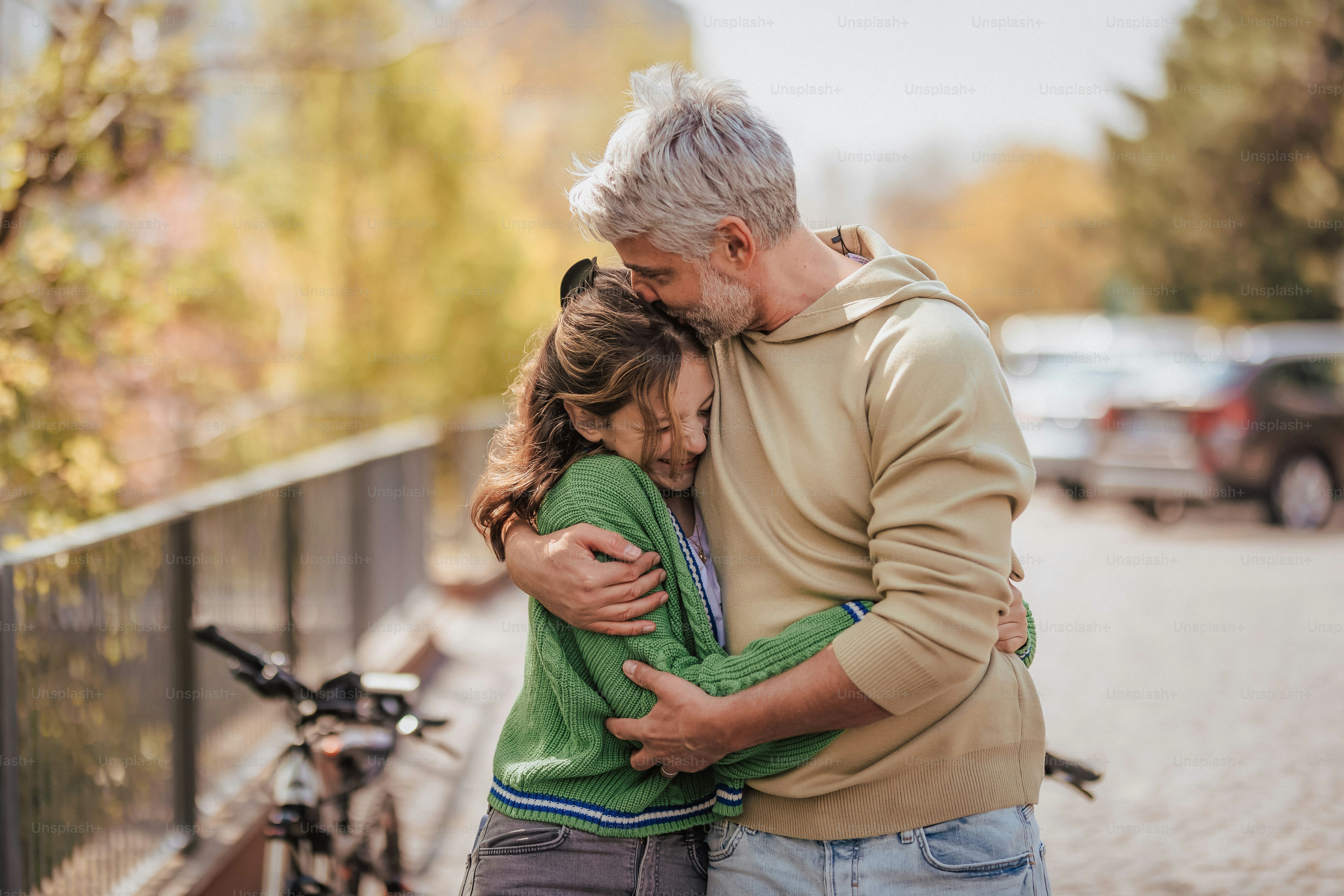 A teenage daughter hugging her father outside in town when spending time  together. photo – Portrait Image on Unsplash
