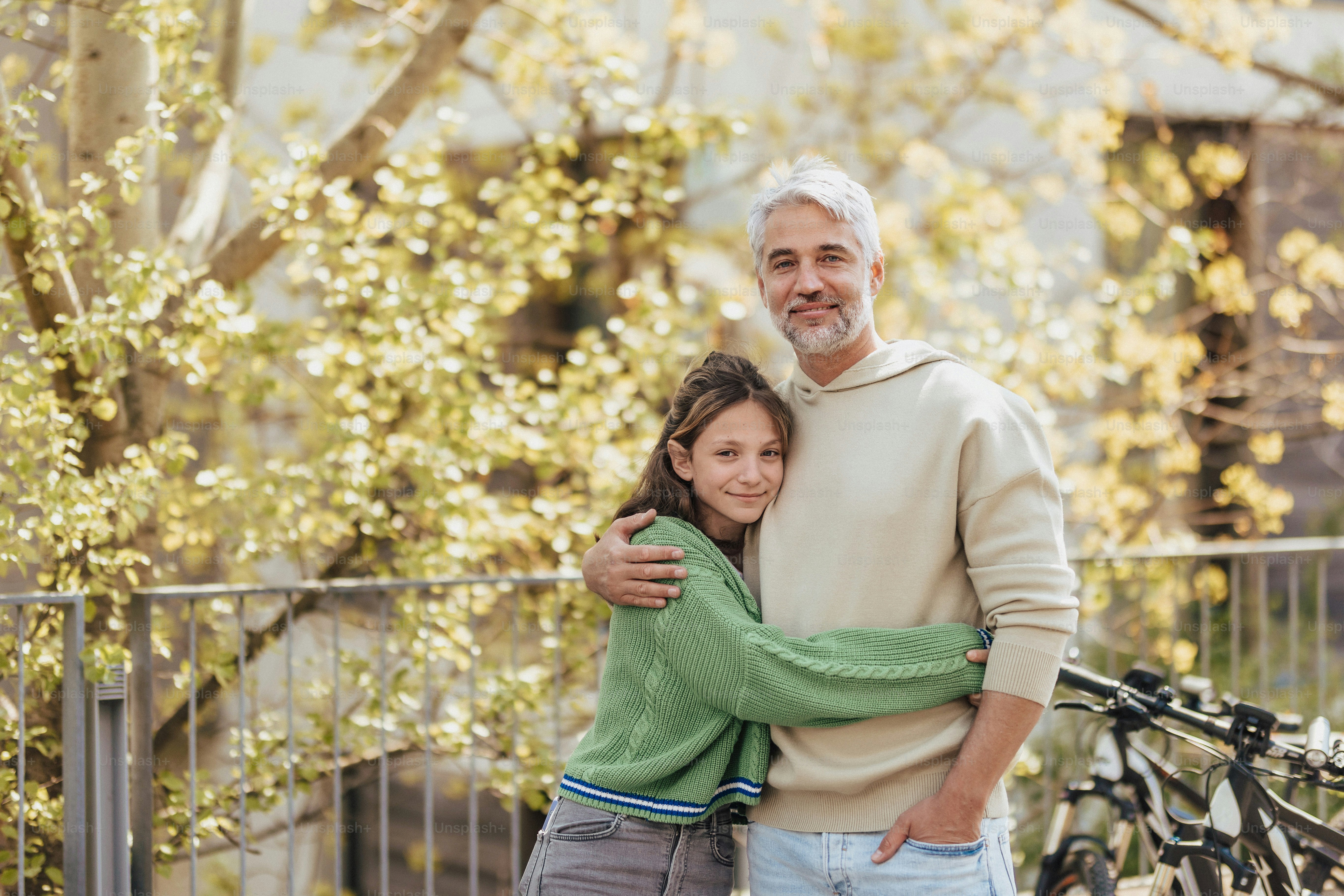 A teenage daughter hugging her father outside in town when spenidng time  together. photo – Portrait Image on Unsplash