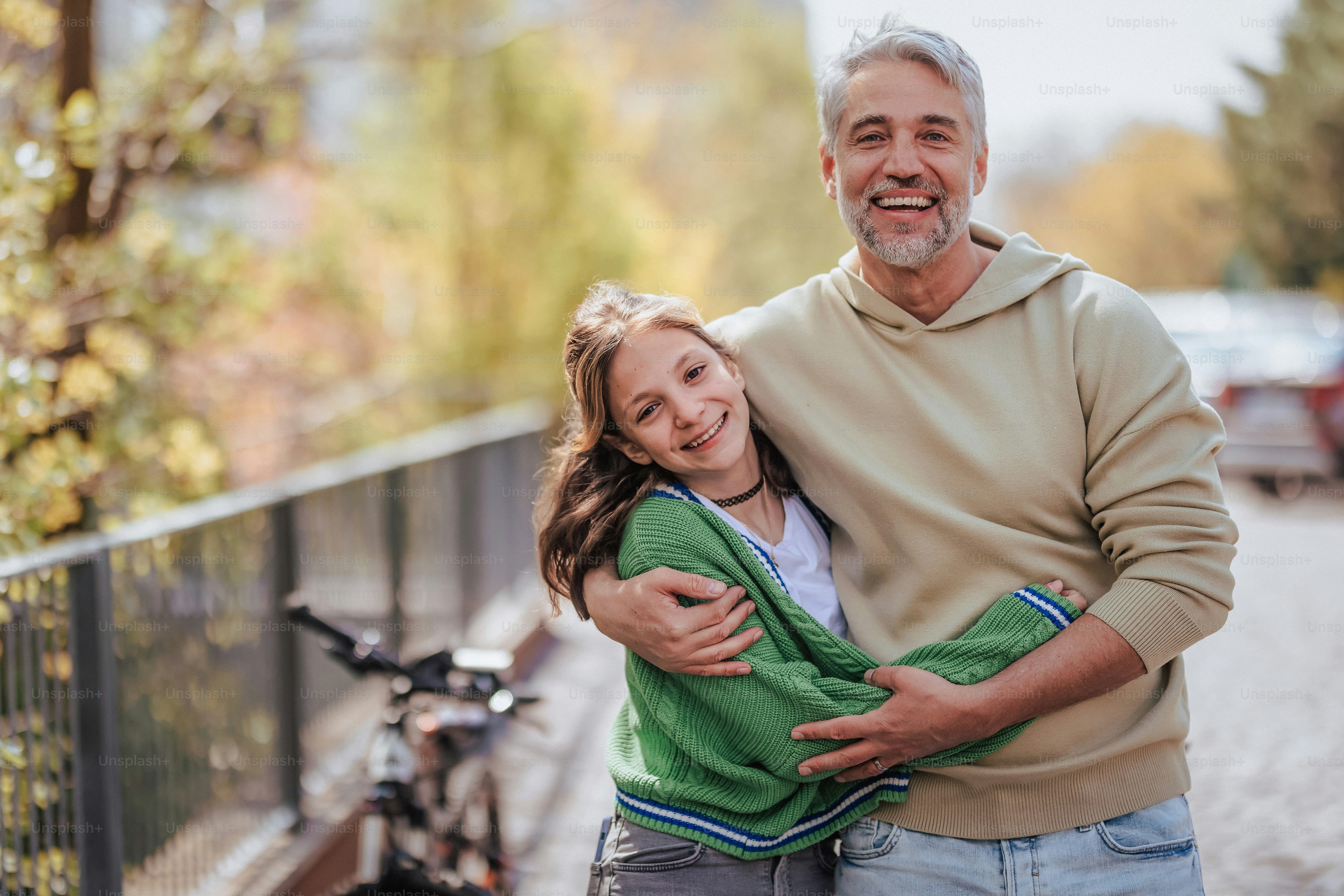 A teenage daughter hugging her father outside in town when spenidng time  together. photo – Portrait Image on Unsplash
