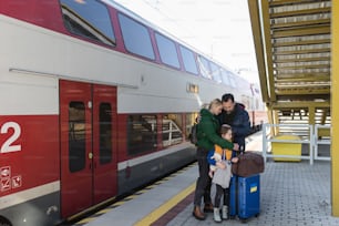 An Ukrainian refugee family with luggage at railway station together, Ukrainian war concept.