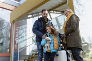 An Ukrainian refugee family with luggage at railway station together, Ukrainian war concept.