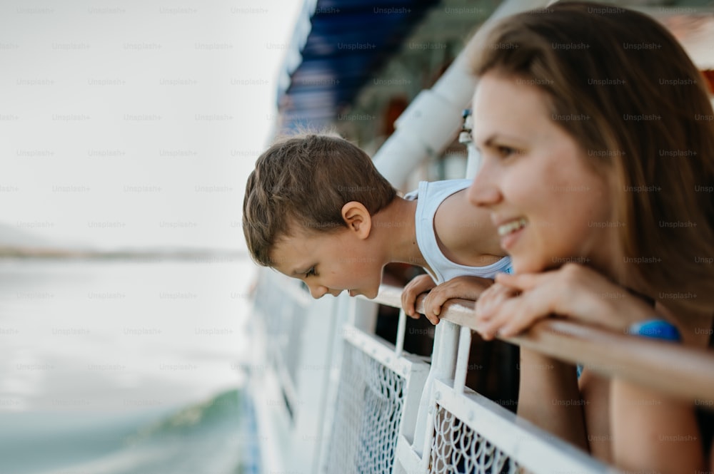 A little curious boy with his mother looking out from motor boat.