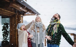 Happy family with small daughter having fun on terrace outdoors, holiday in winter nature.