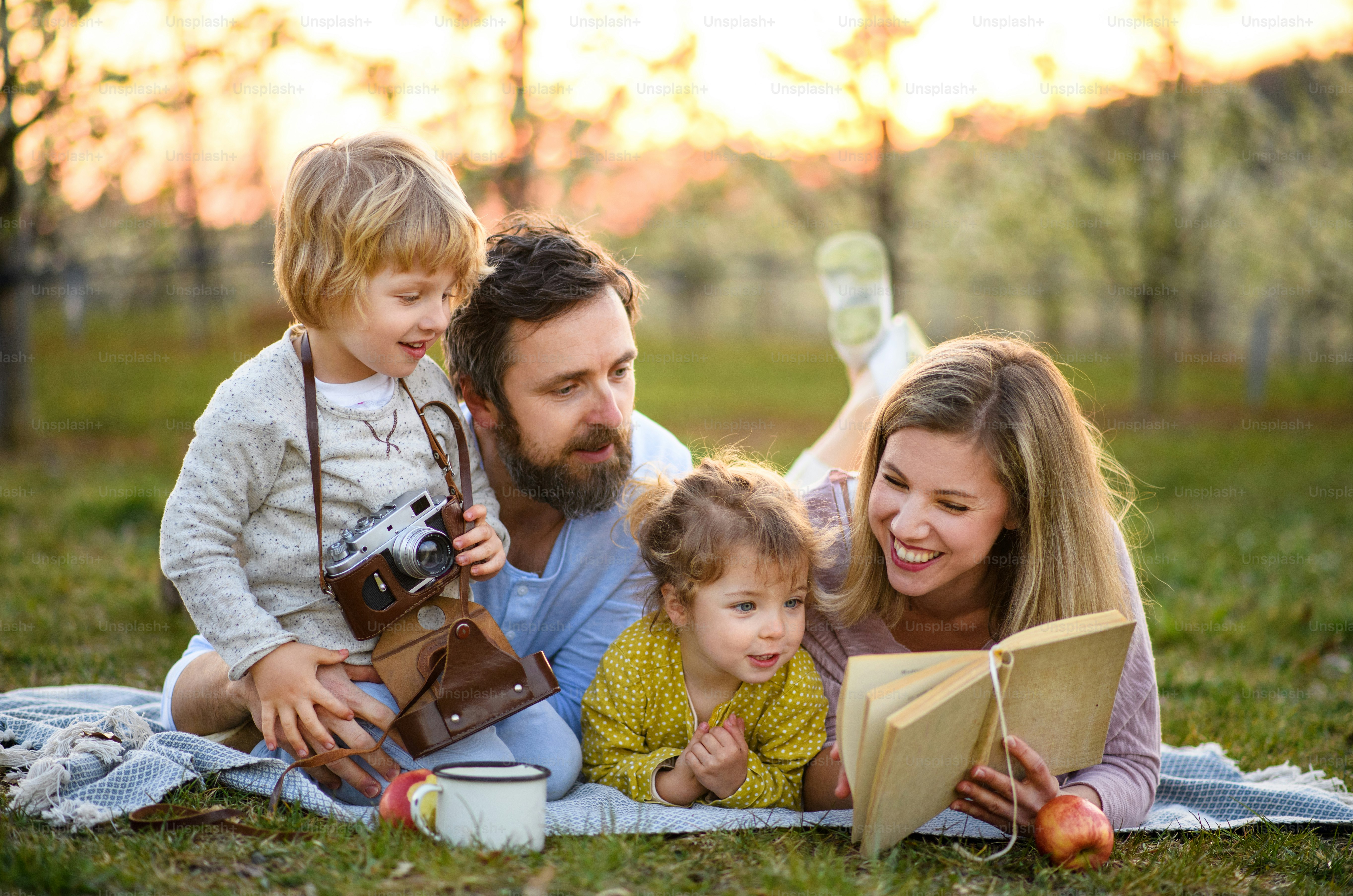 Familie und zwei kleine Kinder mit Kamera und Buch im Freien im Frühling Natur ruhen.