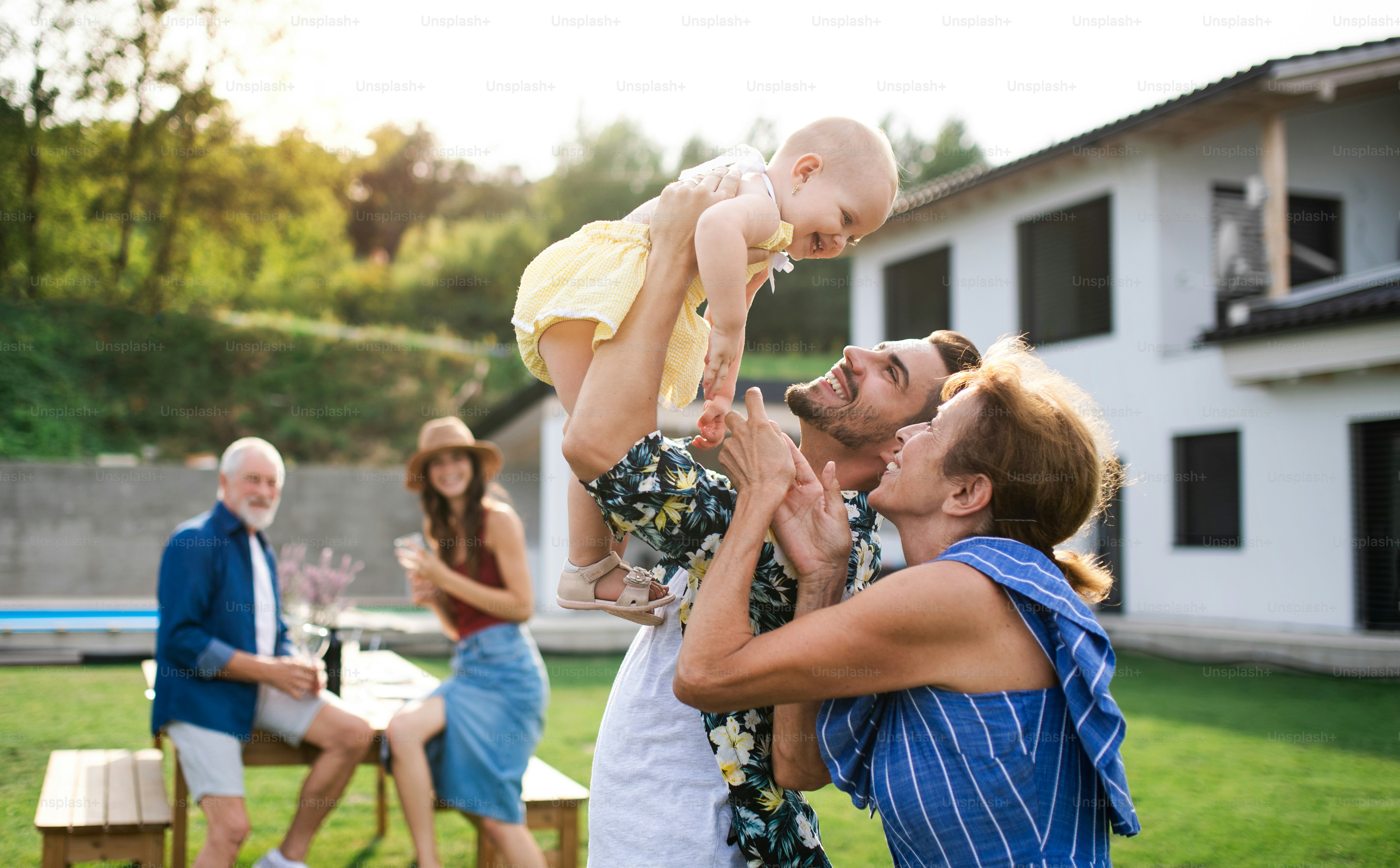 Un portrait de famille multigénérationnelle en plein air sur barbecue de jardin.