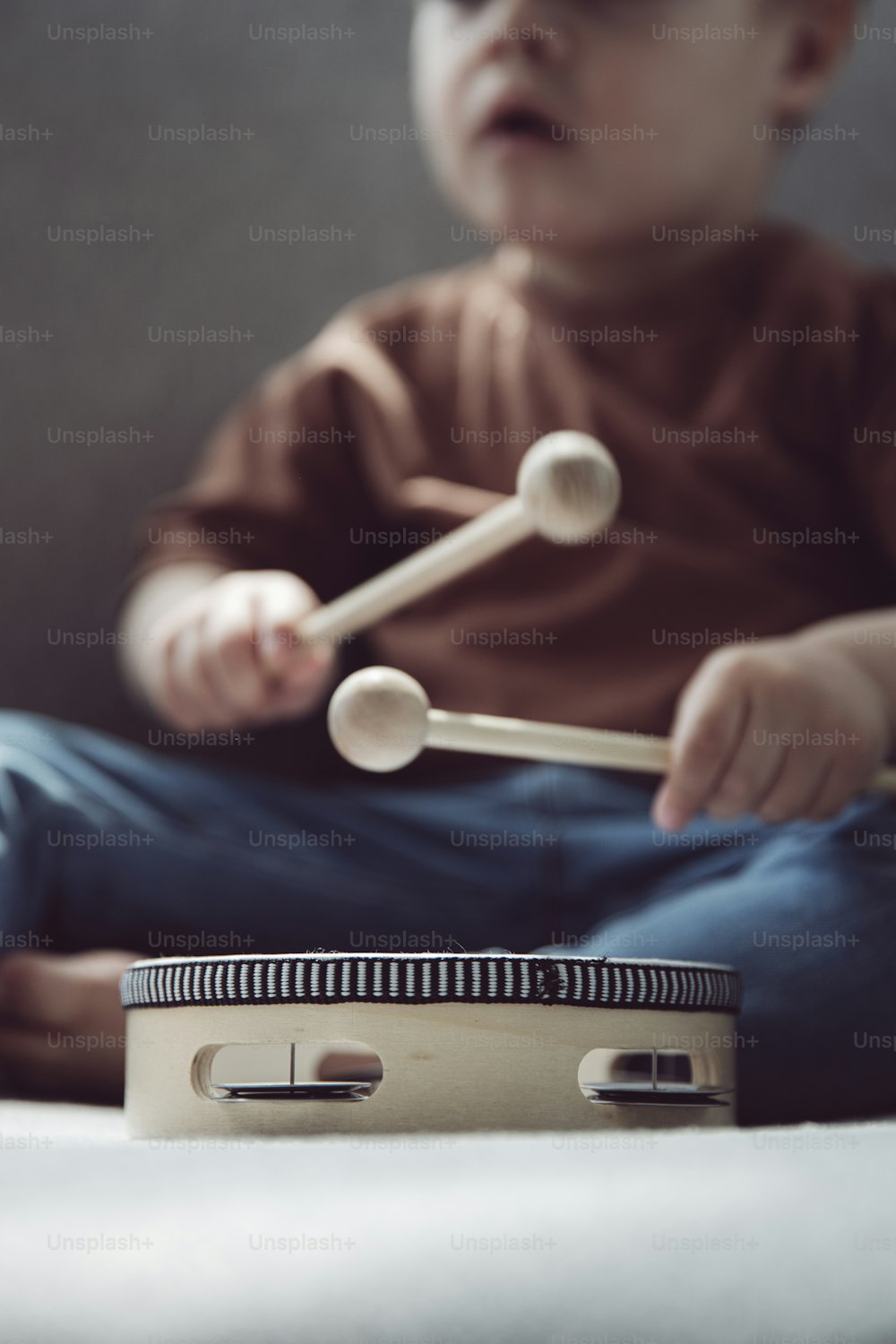 a small child playing with a musical instrument