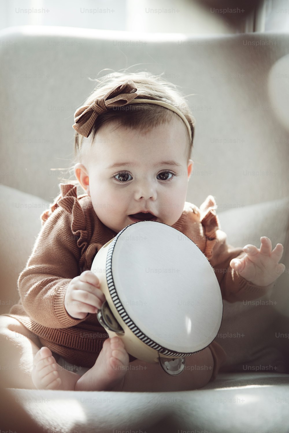 a baby sitting in a chair holding a drum
