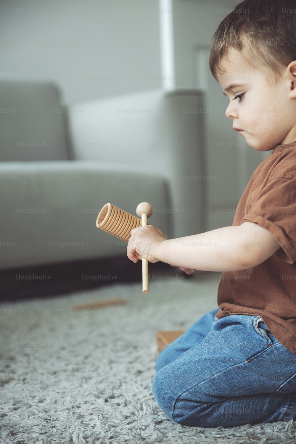 Ein kleiner Junge, der auf dem Boden sitzt und mit einem Spielzeug spielt