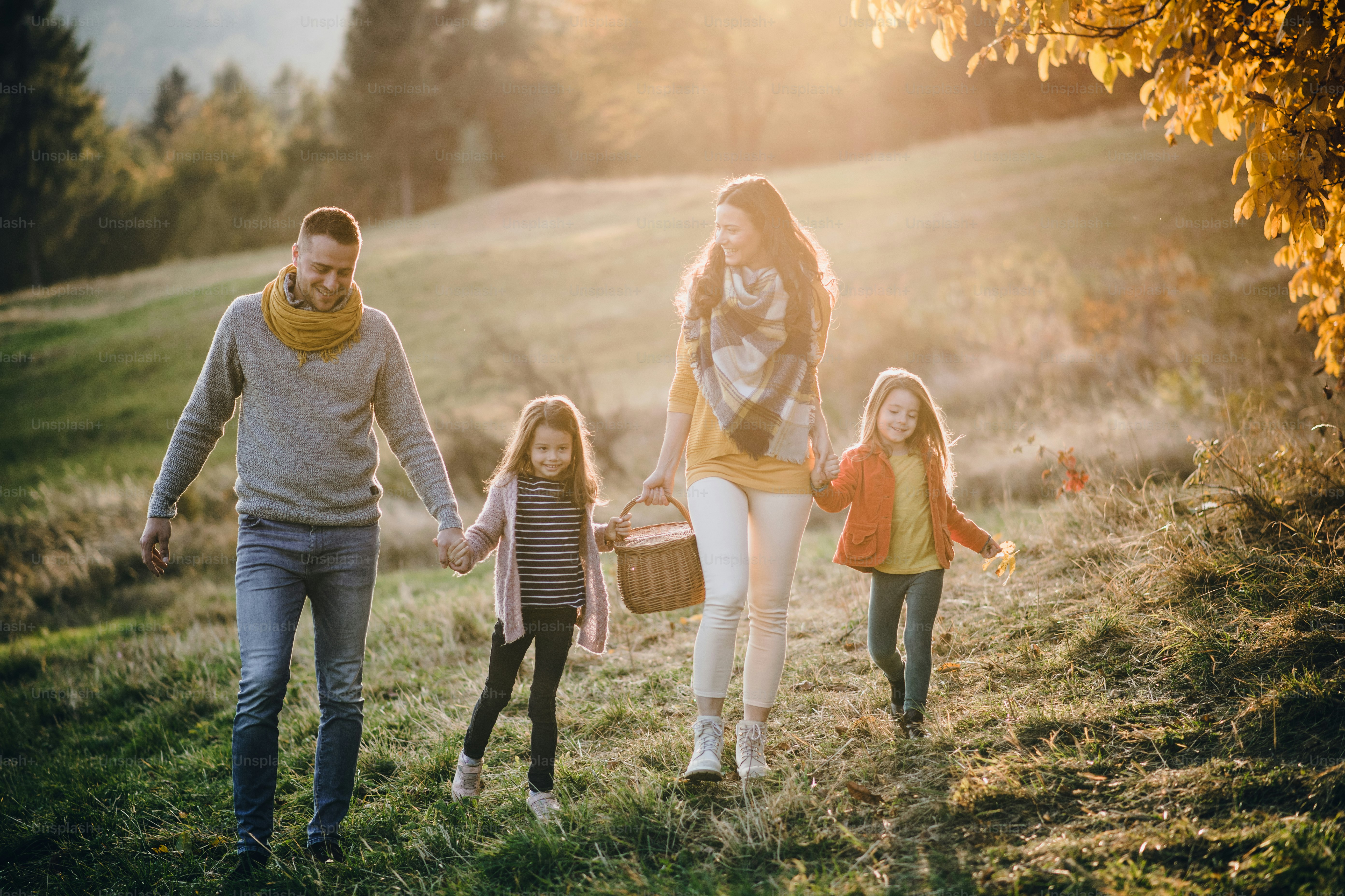 Foto Una familia joven y feliz con dos niños pequeños caminando en la ...