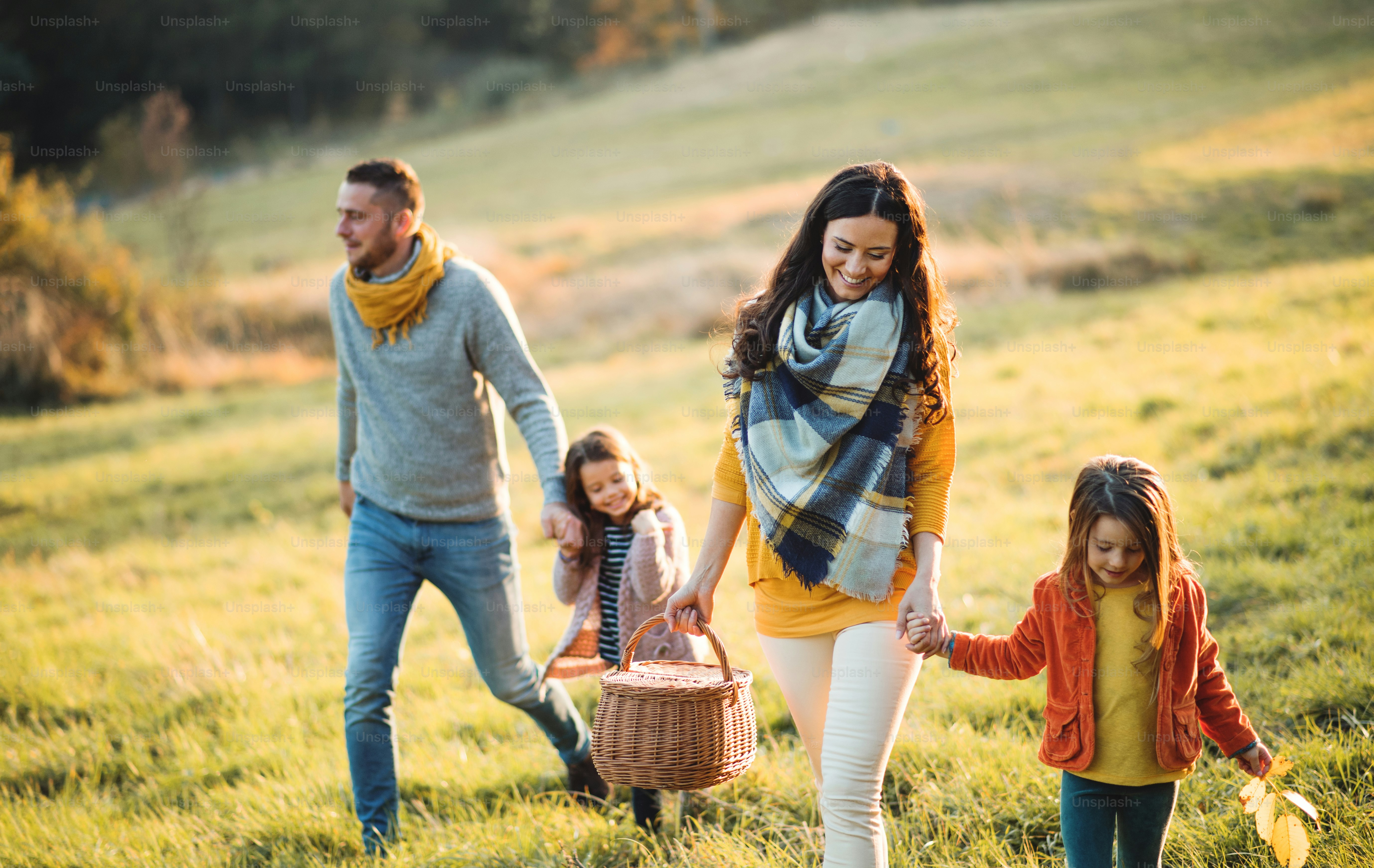 Foto Una familia joven y feliz con dos niños pequeños caminando en la ...