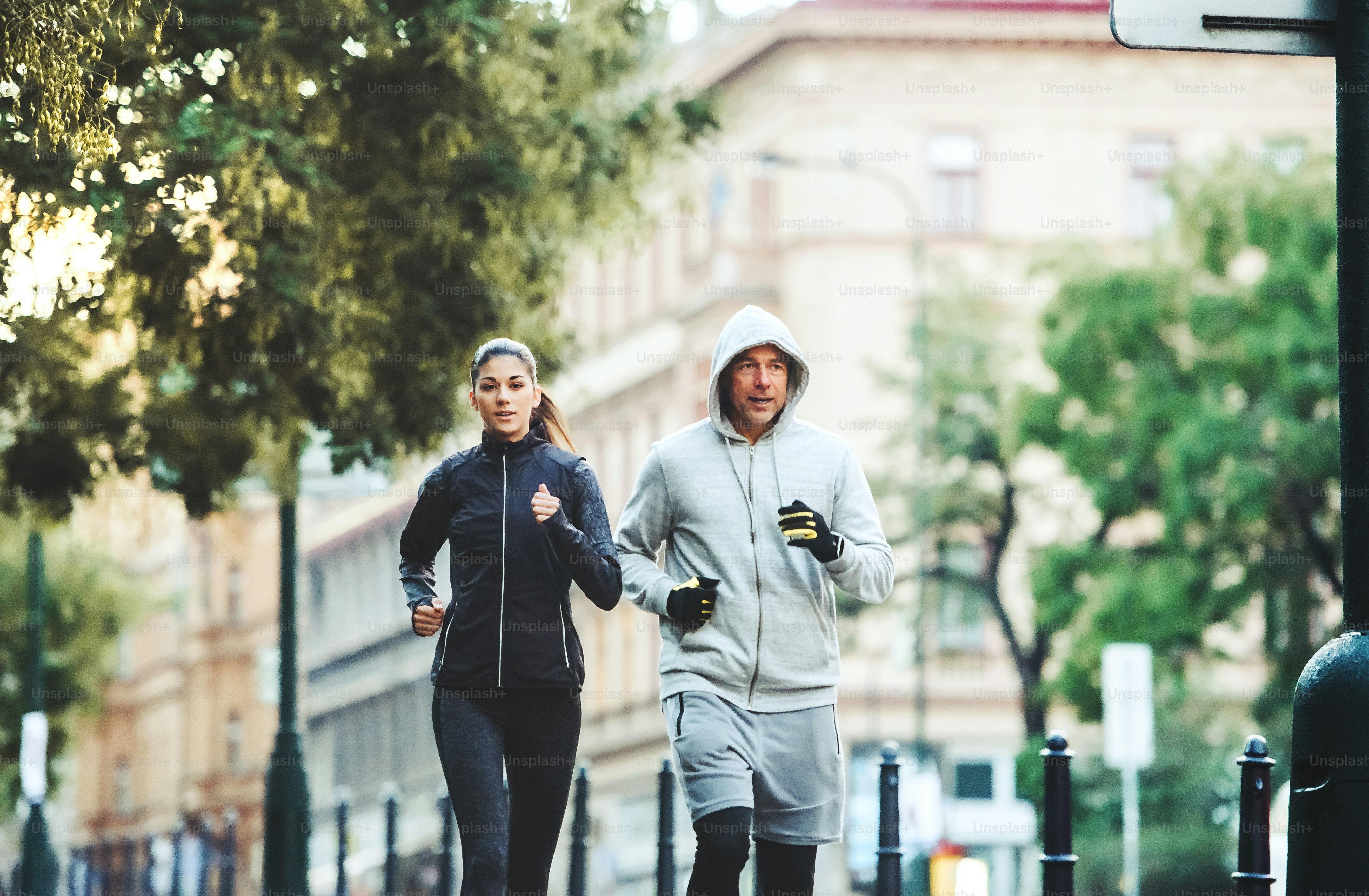 A fit sporty couple running outdoors on the streets of Prague city, Czech Republic
