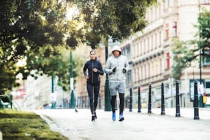 A fit sporty couple running outdoors on the streets of Prague city, Czech Republic.
