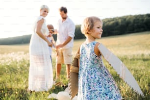 A young family with small children playing on a meadow in nature.