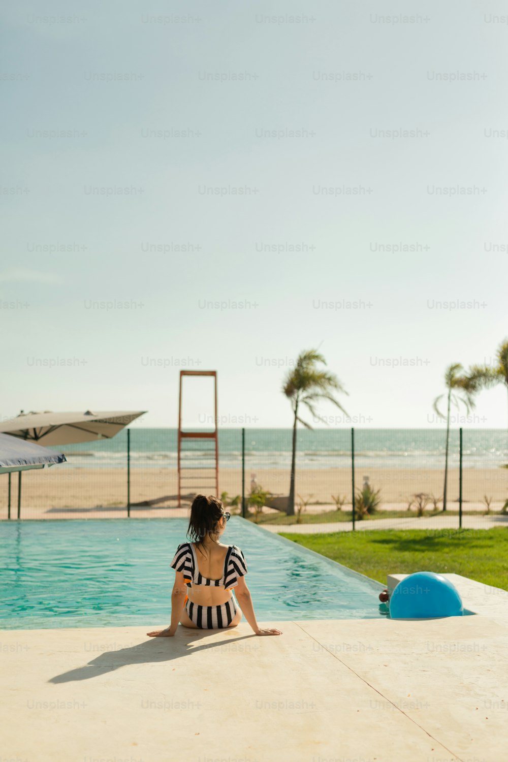 a woman sitting on the edge of a swimming pool